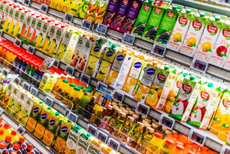 Juice boxes and cold drinks in a commercial refrigerator with electronic shelf labels